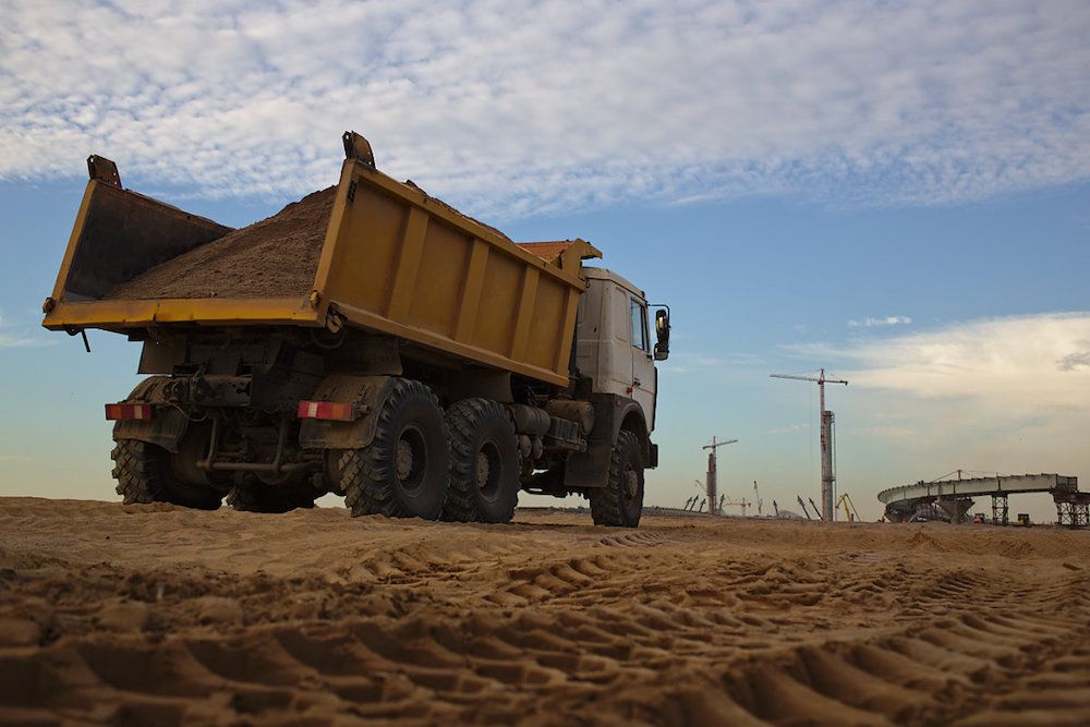 Для ускорения уплотнения грунт проливают и утрамбовывают. В общей сложности здесь уложат несколько миллионов кубометров песка