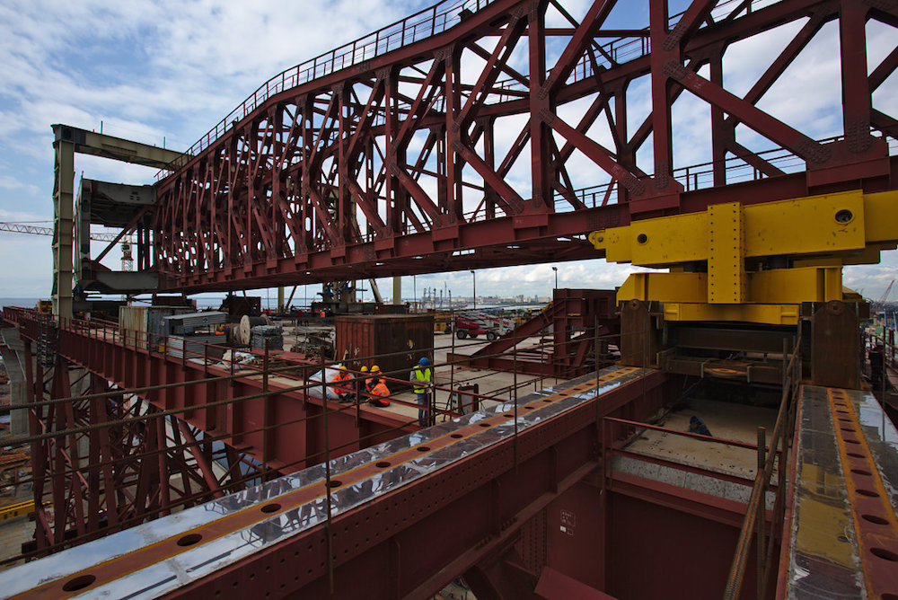 Стапель на Канонерском острове — внушительное временное сооружение размером 30 на 90 метров, возведенное между двумя опорами. Строительство моста через Морской канал и прилегающих к нему участков ведется методом надвижки. На желтых рамах расположены роллеры, по которым перемещают аванбек (вспомогательный элемент 100-метровой длины) и вслед за ним — пролетное строение